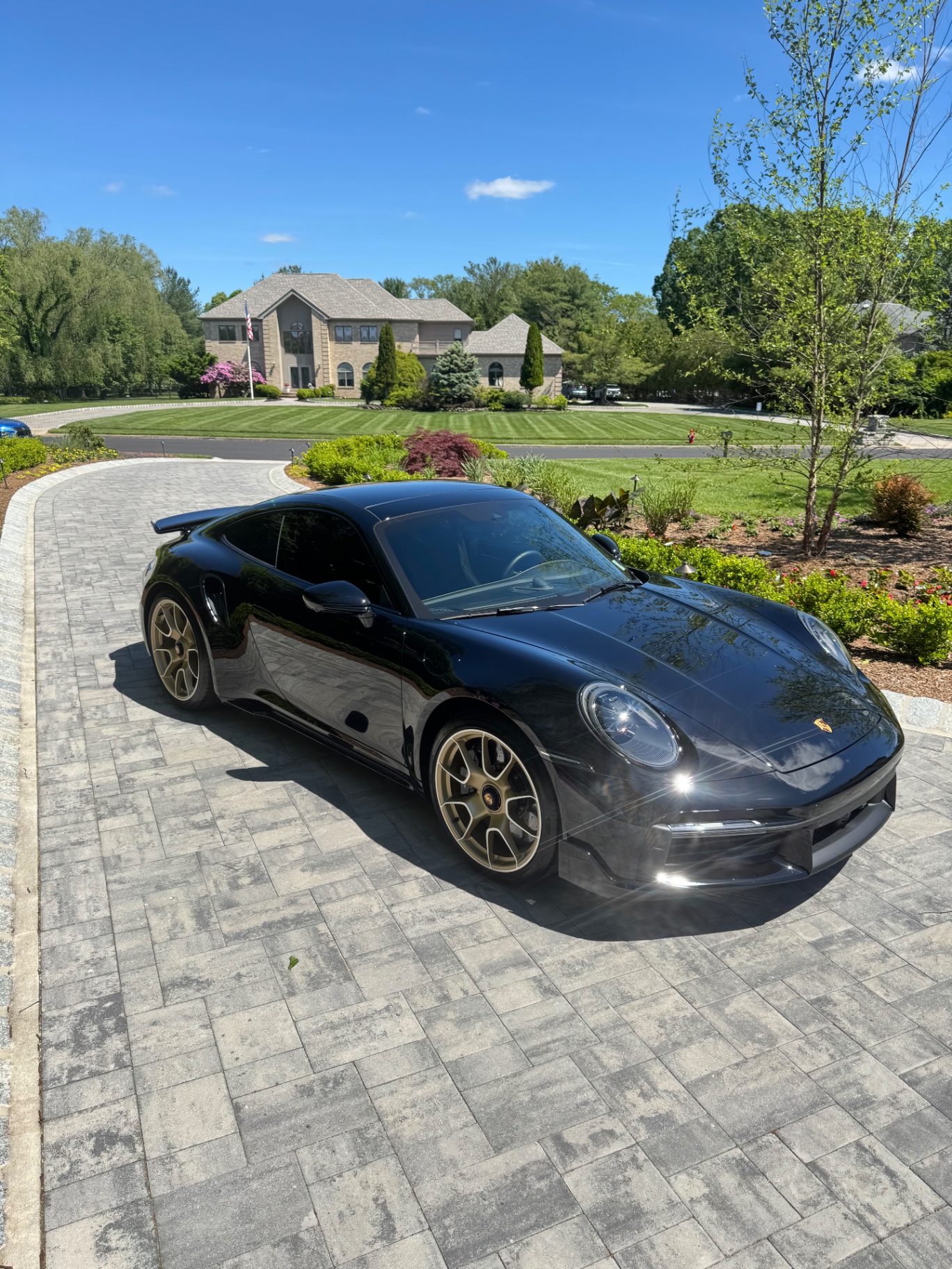 Black Porsche 911 Turbo S with gold wheels detailed by Monmouth Detail Co in a Monmouth County, NJ driveway